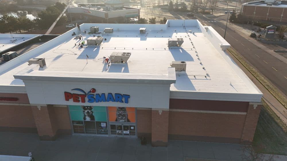 Roofing technician performing scheduled preventative maintenance on a commercial roof