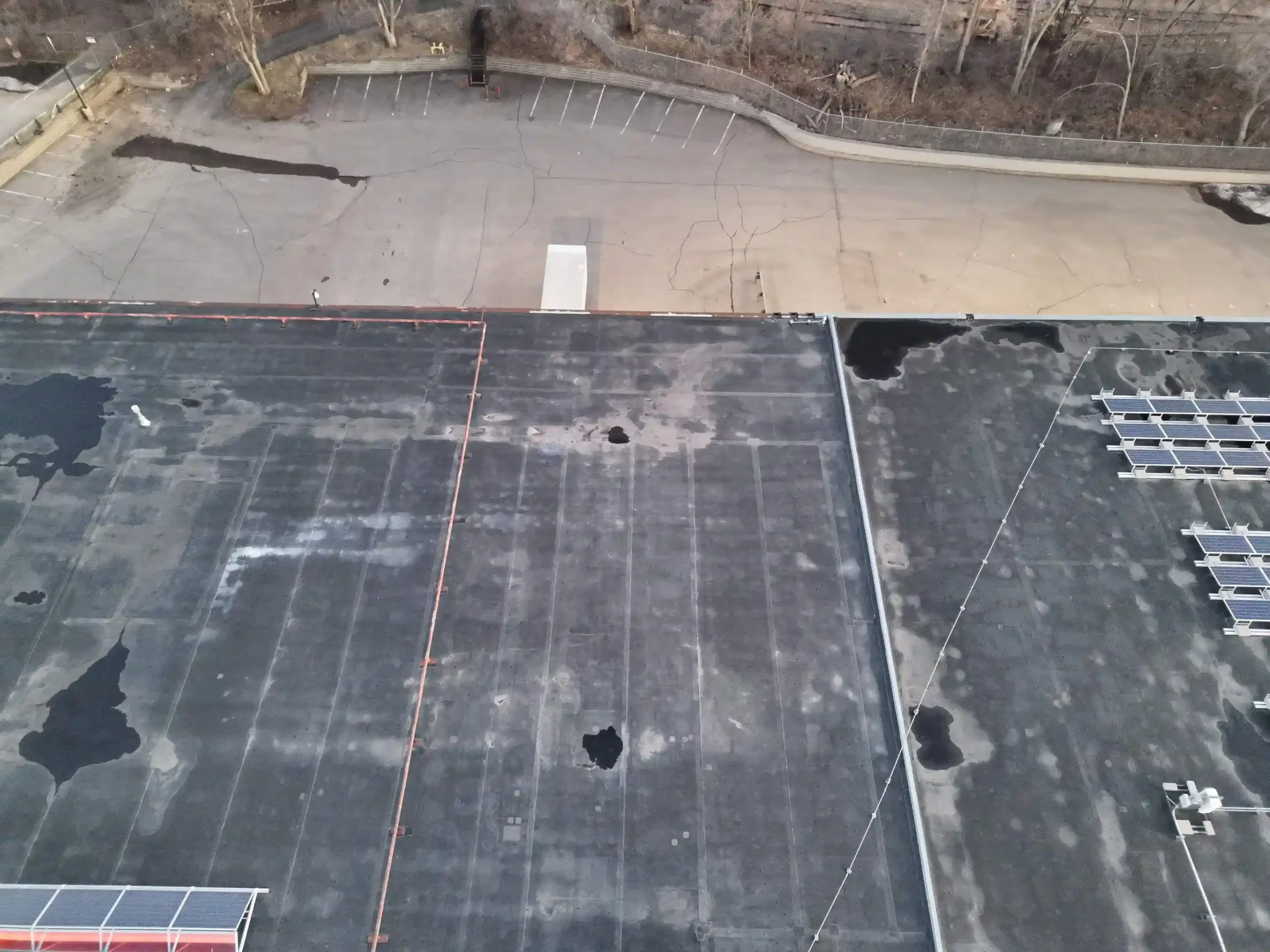 Daylight drone capture of a commercial roof showing seams, flashing, drainage, and rooftop equipment